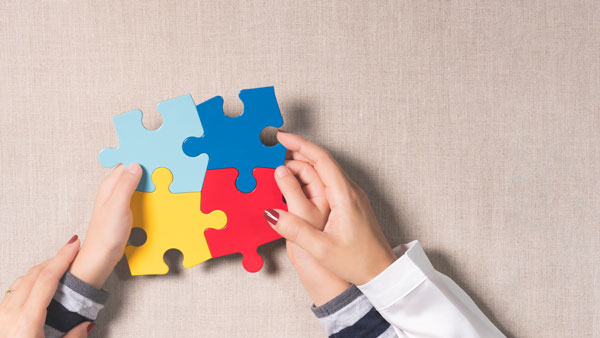 Parent helping child hold puzzle pieces