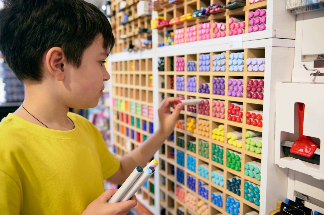 Child with ADHD organizing school supplies into labeled bins to practice study skills