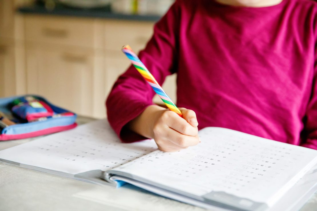 Young child working one-on-one with a tutor using colorful educational materials