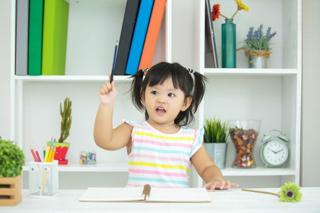 Child learning executive functioning by organizing school materials and developing time management strategies at a desk