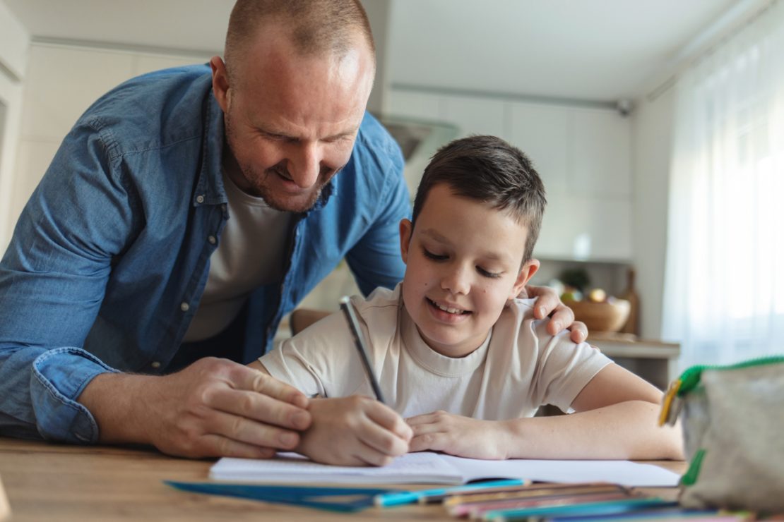A parent helping their child review a school checklist and set up a homework space to support a confident, organized transition back to school after the holidays.