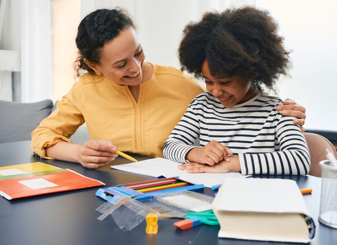 A tutor and student working one-on-one with books and learning tools, illustrating personalized academic support for diverse learners.