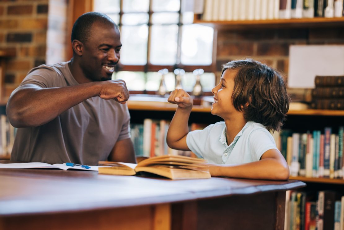 A tutor working one-on-one with a student using a planner and visual tools, illustrating executive functioning coaching for a child with ADHD.