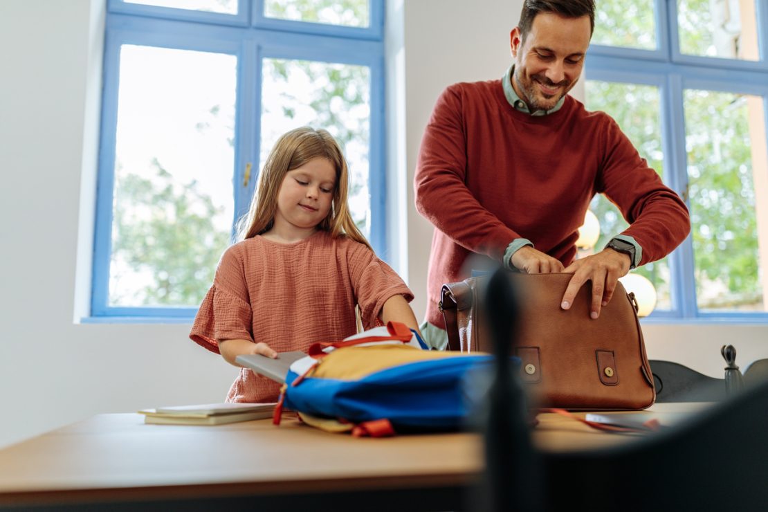 A parent helping a student organize school supplies, assignments, and a planner to prepare for a successful new school year.