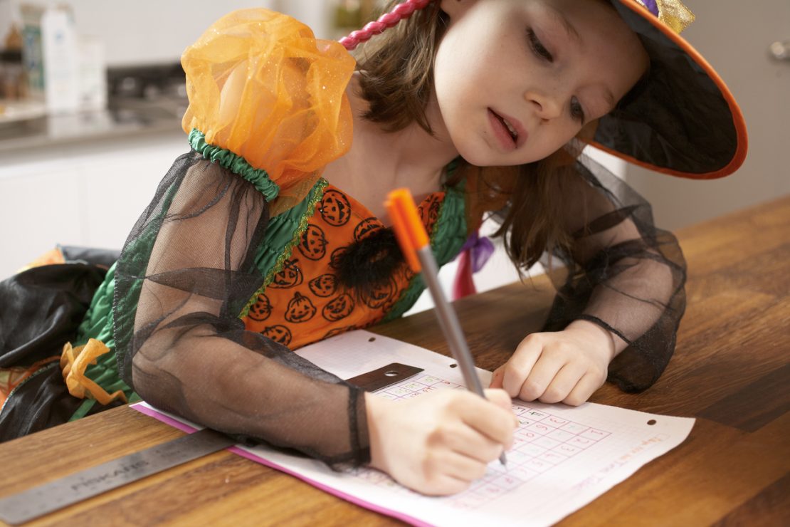 A child using a checklist to plan a Halloween costume while practicing organization, time management, and other executive functioning skills.